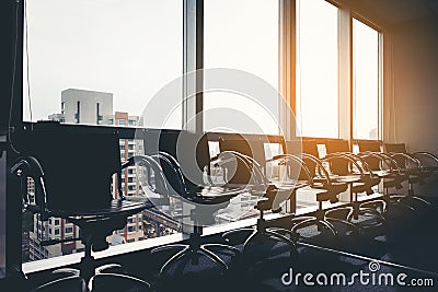 Row of modern black chair in empty office space with large window view cityscape, vintage picture style process, business meeting Stock Photo