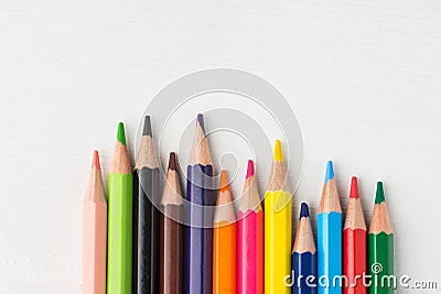 Row of multicolored rainbow palette pencils on white wood background. School art education kids creativity concept. Poster banner Stock Photo