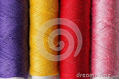 Row of multicolored rainbow palette sewing threads on cardboard spools. Crafts hobbies local artisan business interior decoration Stock Photo