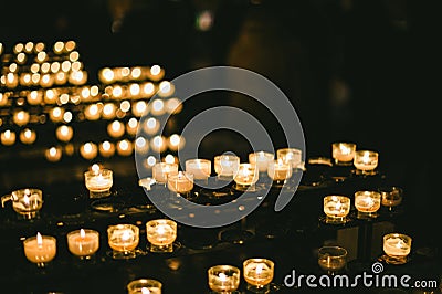 Multiple candles light in a row in Strasbourg Notre-Dame cathedral during Stock Photo