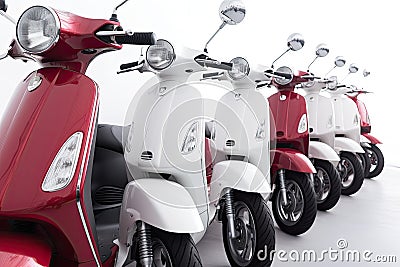 Row of new red and white scooters. Sale or rent concept isolated on white background. Generative AI Stock Photo