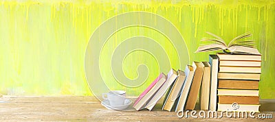 Row of old books and a cup of coffee on a rustic book shelf. Stock Photo