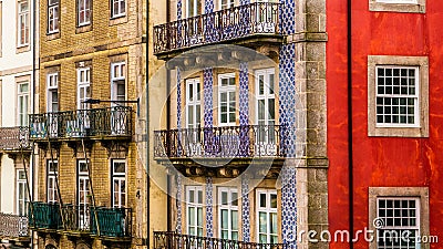 Row of old, colorful buildings with ornate balconies and tiles line a street in Porto, Portugal Stock Photo