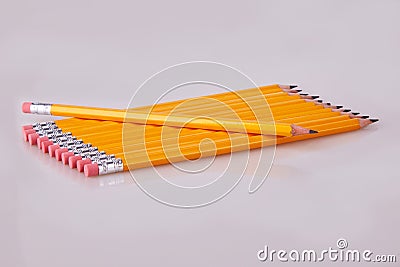 A row of pencils enter top left at an angle with erasers flush Stock Photo