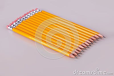 A row of pencils enter top left at an angle with erasers flush Stock Photo