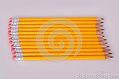 A row of pencils enter top left at an angle with erasers flush Stock Photo