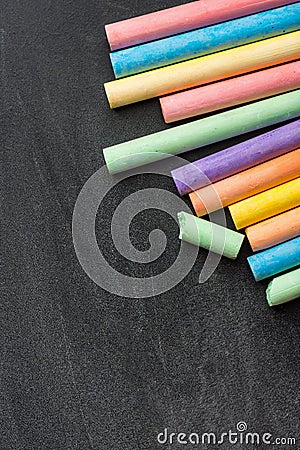 Row Pile of Multicolored Chalks Crayons on Dark Scratched Blackboard. Back to School Business Creativity Graphic Design Stock Photo