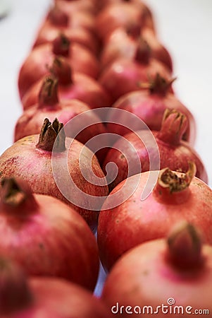 A row of pomegranates fruit isolated on a white background, close-up Stock Photo