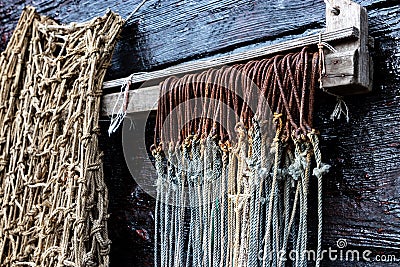 Row Of Rusty Big Game Fish Hooks Hangs Next To Fishing Net Stock Photo
