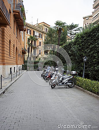 Row of scooters parked in a courtyard in Rome Stock Photo