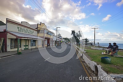 Row of shops, main road Beach Street & local Fijian chatting near sunset at Levuka, Ovalau island, Fiji Editorial Stock Photo