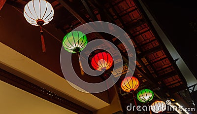 Row of six different color illuminated Chinese paper lanterns Stock Photo