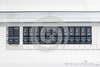 A row of switched off household electrical circuit breakers on a wall panel Stock Photo