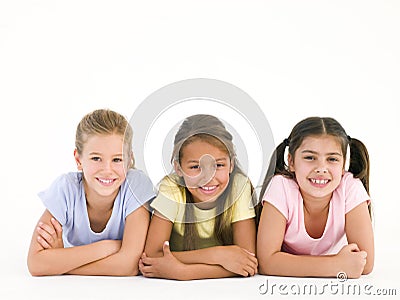 Row of three friends lying down smiling Stock Photo