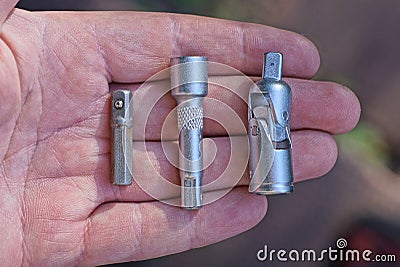 A row of three pieces of gray metal adapters for a screwdriver Stock Photo