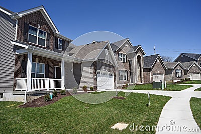 Row of two-story new residential homes for sale side by side in new subdivision grass yards and garages Editorial Stock Photo