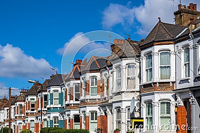 A row of typical British terraced houses in London with an estate agent sign Stock Photo