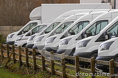 Row of white commercial vans in a dealership for sale or rent. Used and new busses. Transport industry Stock Photo