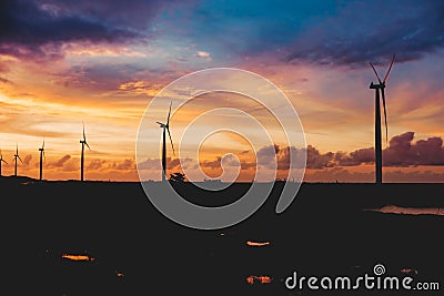 A row of windmills during a dramatic sundown in Bangui, Ilocos Norte, Philippines. Sustainable and renewable energy in Asia Stock Photo