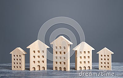 Row of wooden figures of residential buildings. Affordable comfortable housing. Search purchase best option apartment Stock Photo