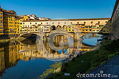 Rowers out on the River Arno during a lovely sunny morning in Florence, Italy, with the historic Ponte Vecchio in the background Stock Photo