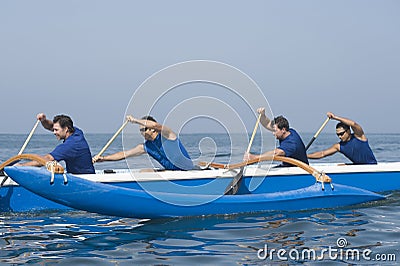 Rowers Paddling Outrigger Canoe In Race Stock Photo