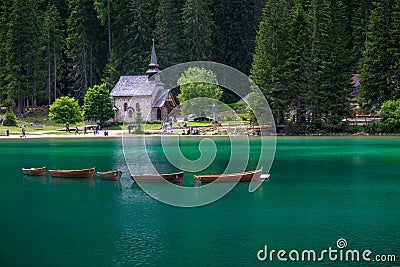 Rowing boats at Braies lake with a church in background Stock Photo