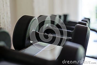 Health care concept. Rows of black dumbbell set on rack in the gym. Weight Training Equipment. Stock Photo