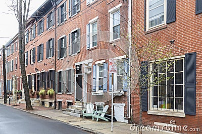 Rows of brownstone apartment buildings in Center City with chairs, stoops and planters in Pennsylvania Stock Photo