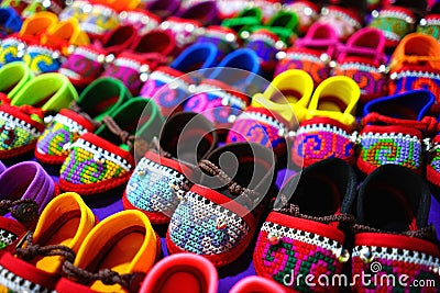 Rows of colorful hand made baby shoes in market Stock Photo