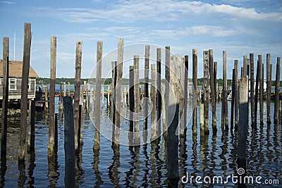 Rows of Dock Piles in Blue Water against Blue Cloudy Sky Stock Photo