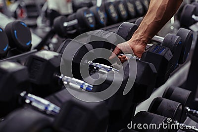 Rows of dumbbells in the gym with hand Stock Photo