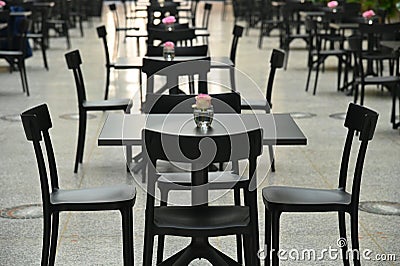 Rows of empty black restaurant terrace tables Stock Photo