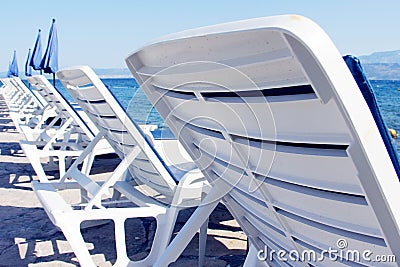 Rows of empty chaise-lounges Stock Photo