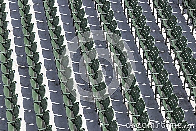 Rows of empty green seats at an outdoor sporting event on a sunny day Stock Photo