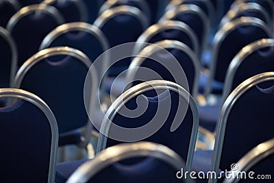 Rows of empty metal chairs in a large assembly hall.Empty chairs in conference hall.Interior meeting room. Back view Stock Photo