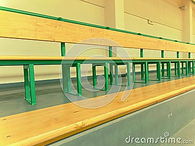Rows of empty wooden benches in school sporting hall. Tribune in gym for fans Stock Photo