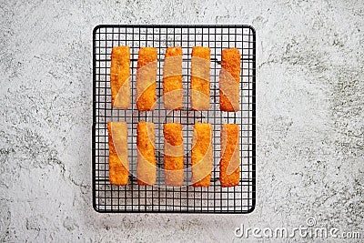 Rows of golden fried fresh fish fingers fillets Stock Photo