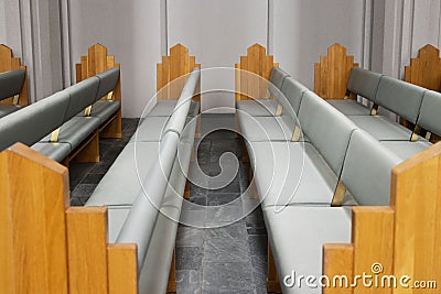 Rows of grey Pews inside of a Church Stock Photo