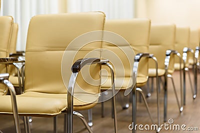 Rows of metal chairs at the conference in an empty room. Front view Stock Photo