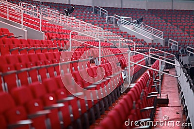 Rows of red numbered seats with armrests Stock Photo