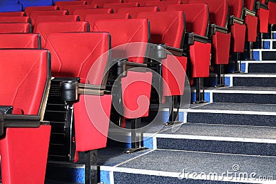 Rows of red seats and grey stairs in auditorium Stock Photo