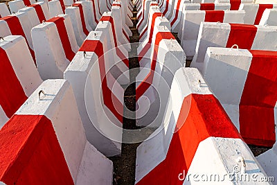 Rows of red and white concrete barriers waiting to be used in traffic control and safety. 2 Stock Photo