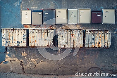 Rows of retro rusty and modern mailboxes on wall. Stock Photo