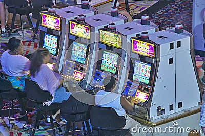 Rows of slot machines and gamblers at Rio Casino in Las Vegas, NV Editorial Stock Photo