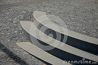 3 rows of stairs in the square are gradually sunk into the paving. Slow transition of the staircase to the plane by blending, inte Stock Photo