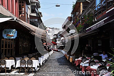 Rows of tables in street cafes. Street with restaurants. Editorial Stock Photo