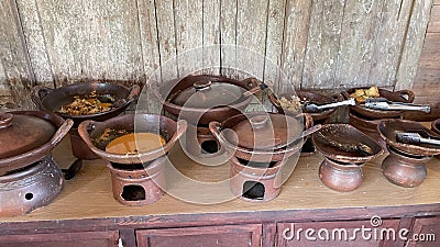 Rows of tiny antique clay cooking utensils on antique wooden tables Editorial Stock Photo