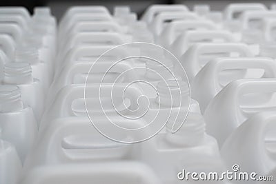Rows of white plastic canisters ready to be filled with chemicals Stock Photo