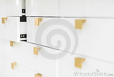 White sleek drawers with golden handles. Stock Photo